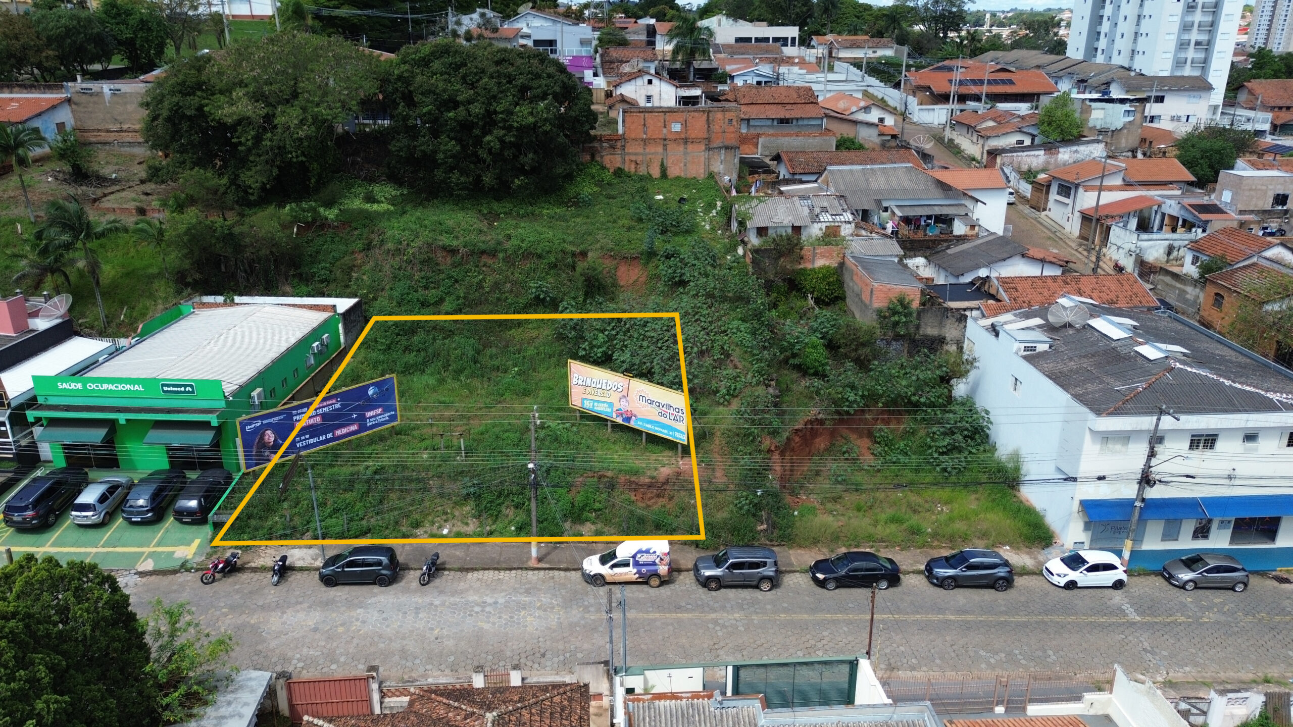 Foto de drone com a área de 296,30 m² demarcada em amarelo, entre a Unimed Saúde Ocupacional e um prédio comercial